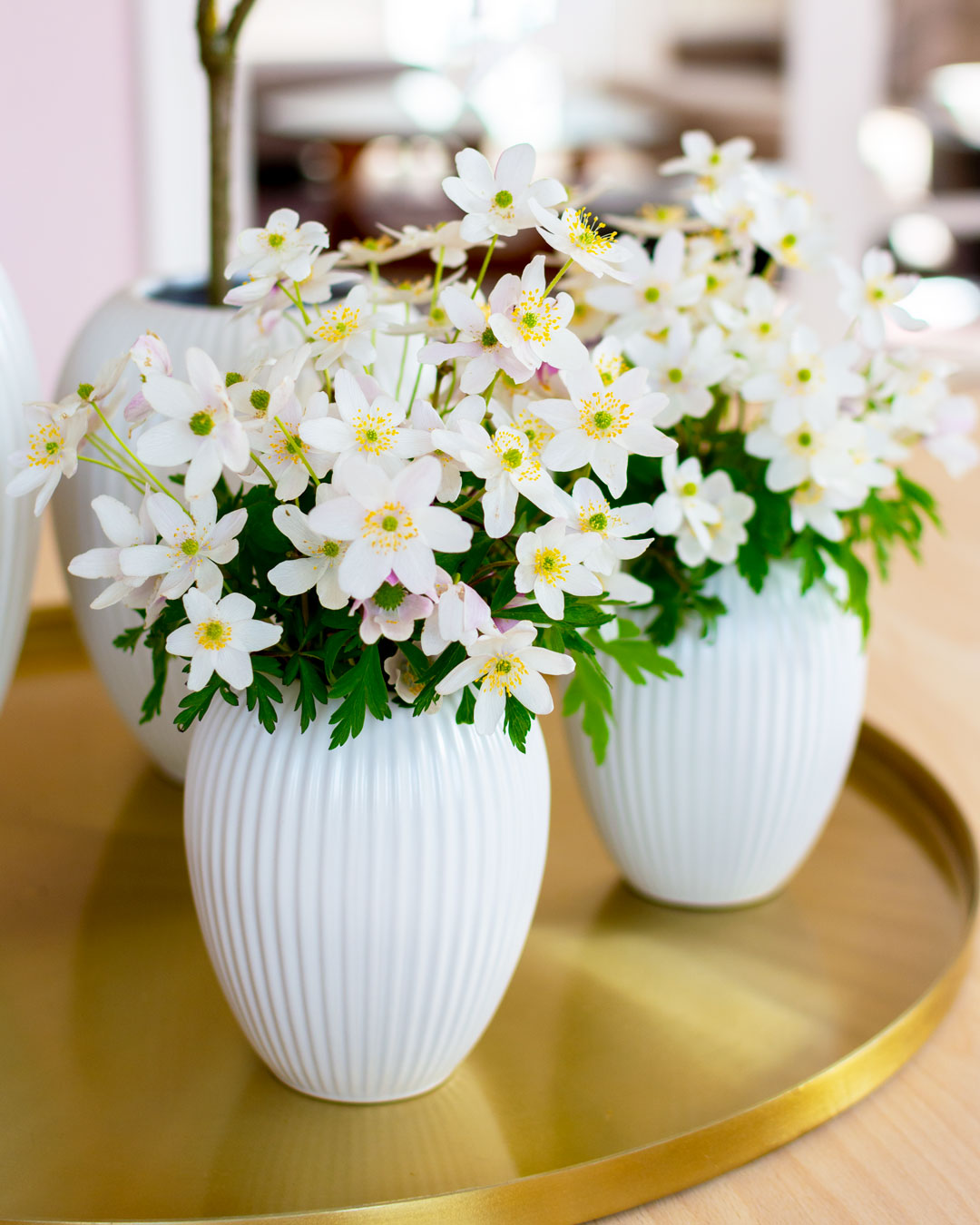 2 Små hvide vaser fra Michael Andersen Keramik Model 4767 i 12 cm med hvide anemoner på messingbakke på spisestuebord af lyst træ