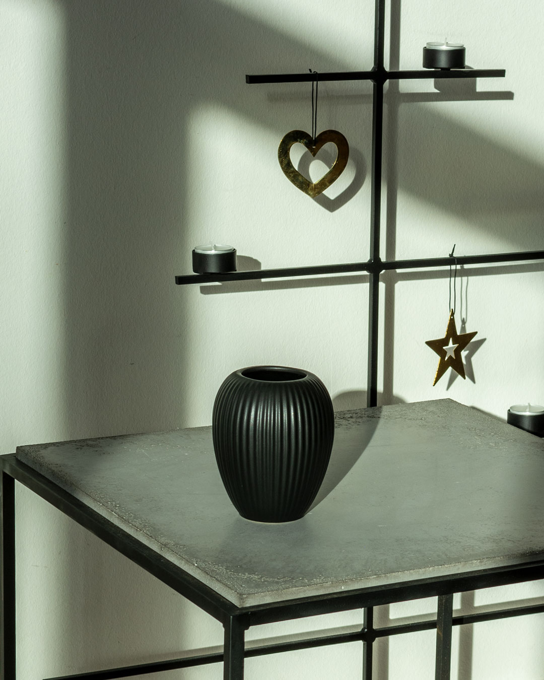Lille sort vase fra Michael Andersen Keramik Model 4767 på lavt betonbord med stærk sol og skygger