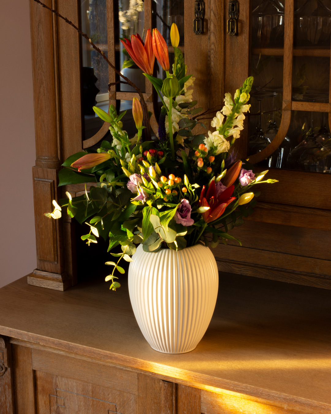 Hvid vase fra Michael Andersen Keramik på skænk med blomster Model 4767 aftensol