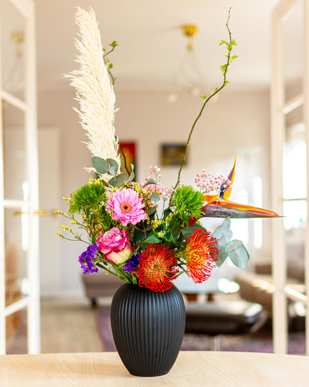 Sort Michael Andersen Keramik vase med diva blomster buket med fjer på spisebord af bøgetræ