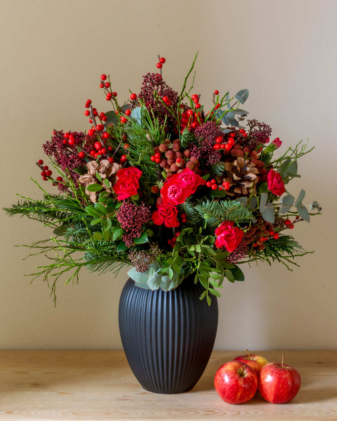 Sort vase fra Michael Andersen Keramik med røde blomster, gran og æbler