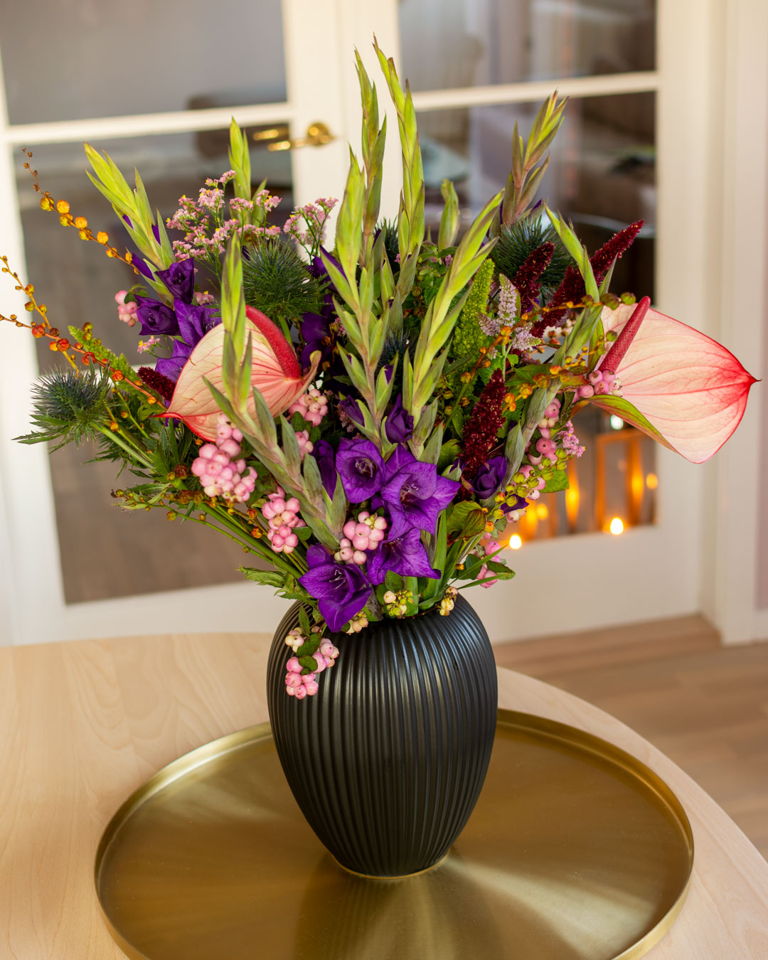 Sort vase fra Michael Andersen Keramik med blomster på messingbakke